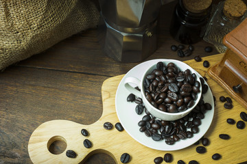 Fototapeta na wymiar The coffee beans vintage mood and tone on wood table