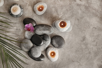 Obraz na płótnie Canvas Beautiful spa composition with stones and candles on grey textured background