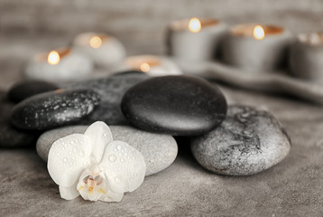 Fototapeta na wymiar Spa stones and beautiful orchid flower on grey table