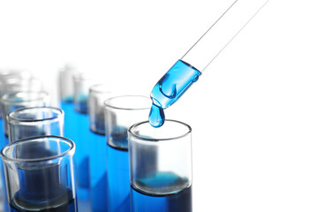 Dripping blue liquid into test tubes on white background