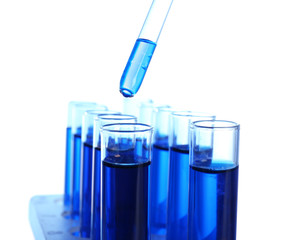 Dripping blue liquid into test tubes on white background