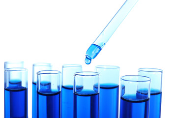 Dripping blue liquid into test tubes on white background