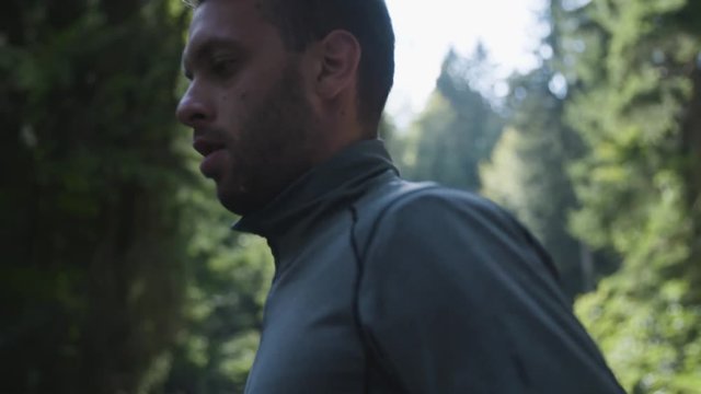 Young man jogging through a fores