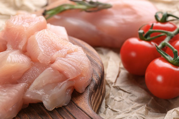 Pieces of raw cut chicken fillet on board, closeup