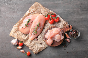 Composition with raw chicken fillet on table