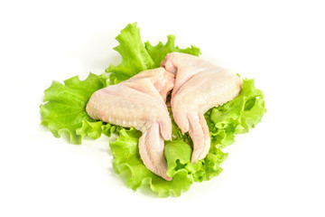 Raw chicken wings and green salad isolated on white background.
