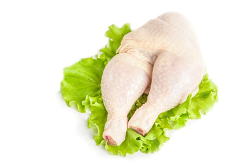 Raw chicken legs and green salad isolated on white background.