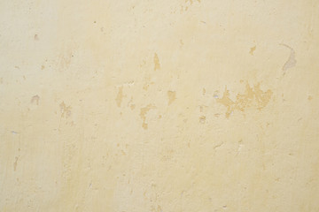 Background of old yellow wall with peeling plaster, texture