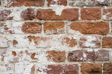 Background of old vintage dirty brick wall with peeling plaster, texture