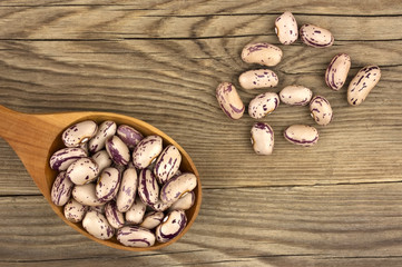 Haricot beans in a wooden spoon on wooden background