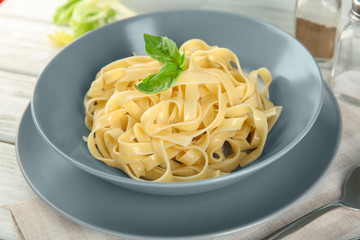 Plate of tasty pasta on table
