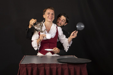 Pareja de actores acróbatas de circo profesionales ensayando una parodia sobre la hora del té en época victoriana