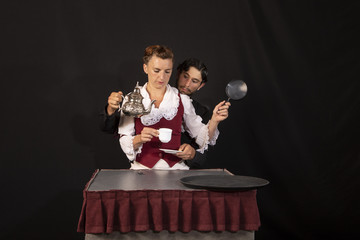 Pareja de actores acróbatas de circo profesionales ensayando una parodia sobre la hora del té en época victoriana