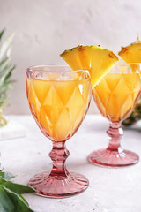 Glasses of tasty fresh pineapple juice on table
