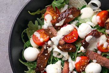 Tasty salad with meat, cherry tomatoes and mozzarella on plate