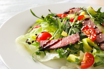 Tasty salad with meat and cherry tomatoes on plate