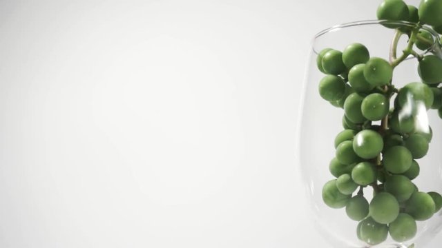  Glass full Green seedless grapes on a white table, rotation 360 degrees. White background.