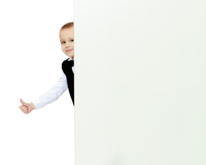 boy peeks out from behind the banner