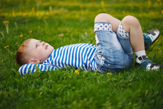 little boy lying on the grass