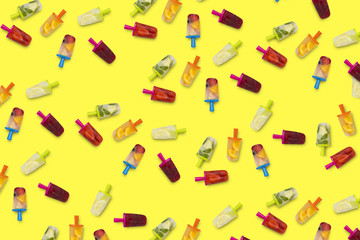 Pattern of fruit popsicles on a yellow background. Strawberry, Lemon, Lemon with mint, Orange, Cherry, Multifruit. Flat lay, top view