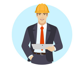 Businessman in construction helmet holding digital tablet PC