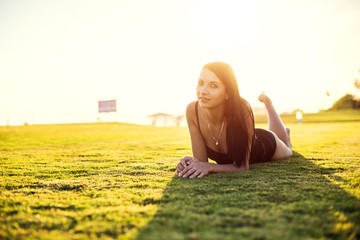 happy beautiful woman in bikini on the green grass on sunset.