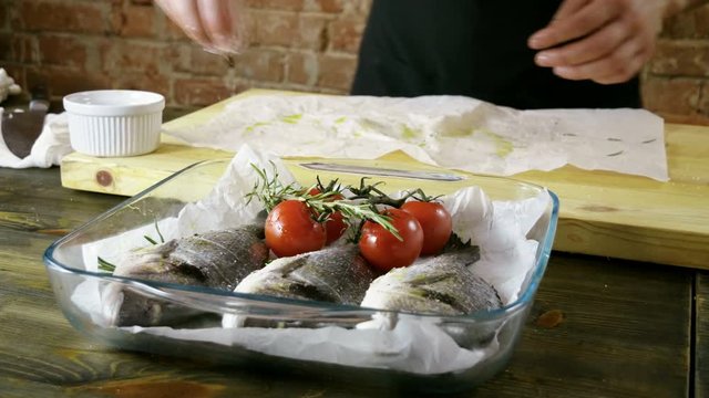 Cooking of three sea bass. The cook preparing fresh fish for baking. 4K