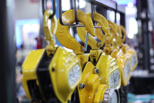 Industrial Steel Chains in yellow hoists ; background