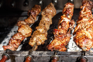 Shish kebabs with grilled meat for barbecue. Close-up pieces of juicy meat on skewers. Preparation of traditional shashlik. B-B-Q. Selective focus
