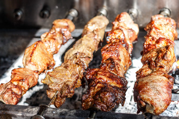 Shish kebabs with grilled meat for barbecue. Close-up pieces of juicy meat on skewers. Preparation of traditional shashlik. B-B-Q. Selective focus