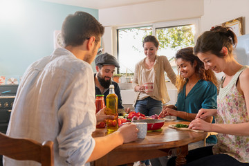 Multi-ethnic group of friends cooking lunch in the kitchen. 