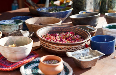 Different types of dry herbal tea leaves on table. Dried herbs, flowers, fruits, spices in ceramic plates stand on the table. Background. Selective focus
