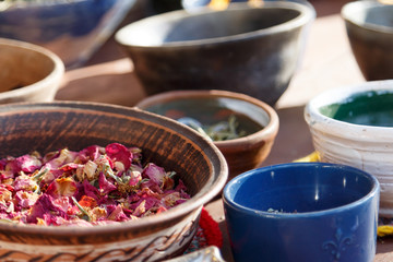 Different types of dry herbal tea leaves on table. Dried herbs, flowers, fruits, spices in ceramic plates stand on the table. Background. Selective focus