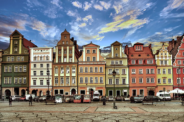 Central market square in Wroclaw Poland with old colourful houses, street lamp and walking tourists people at gorgeous stunning evening sunset sunshine. Travel vacation concept - 208357433