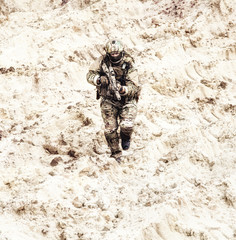 Modern infantry soldier in protective camouflage uniform, in helmet and mask, running with assault...