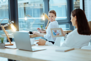 My family. Thoughtful woman sitting on the foreground and holding photo frame while missing her husband