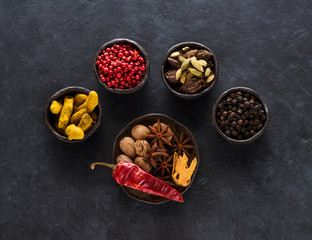 Spice, spicy and seasoning in bowls on a black background