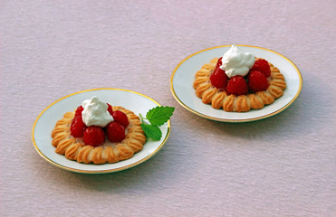 two raspberry tarts on pink background
