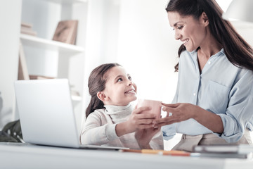 Take it. Beautiful female person expressing positivity while looking at her daughter