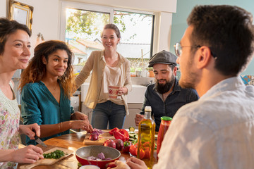 Multi-ethnic group of friends cooking lunch in the kitchen. 