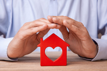 Concept home insurance, protection from burglary or destruction. Man with his hands covers the...