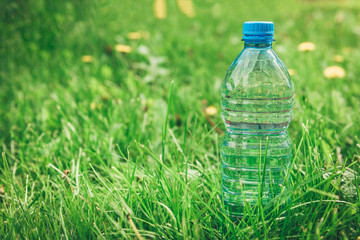 Bottle of water on grass background.