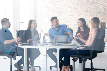 Young people having business meeting in office, view through glass