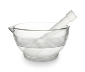 Glass mortar with water and pestle on white background