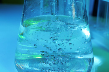 Test flask with water on color background, closeup