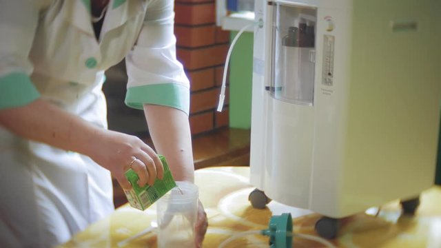 Woman make oxygen cocktail with device for oxygen scum. Oxygen cocktail for woman. Woman make oxygen cocktail with device for oxy scum