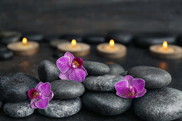 Obraz na płótnie Canvas Spa stones and beautiful orchid flowers on dark background