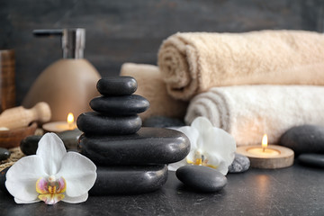 Beautiful spa composition with stones and orchid flower on table