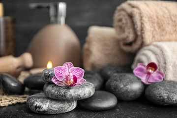 Beautiful spa composition with stones and orchid flowers on table