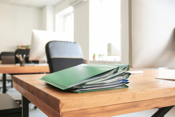 Workplace with computer and folders on table in modern office